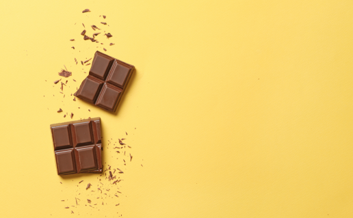 Two squares of chocolate on yellow background