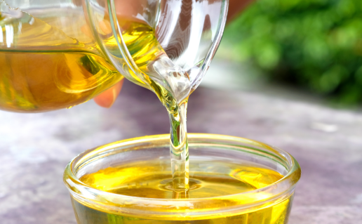 Pitcher pouring cooking oil into bowl