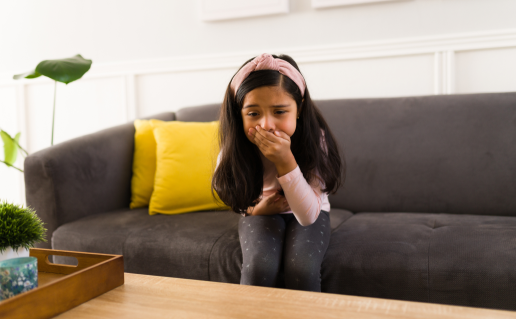 Little girl with hand on her mouth, about to vomit