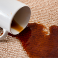 White mug spilling coffee on carpet